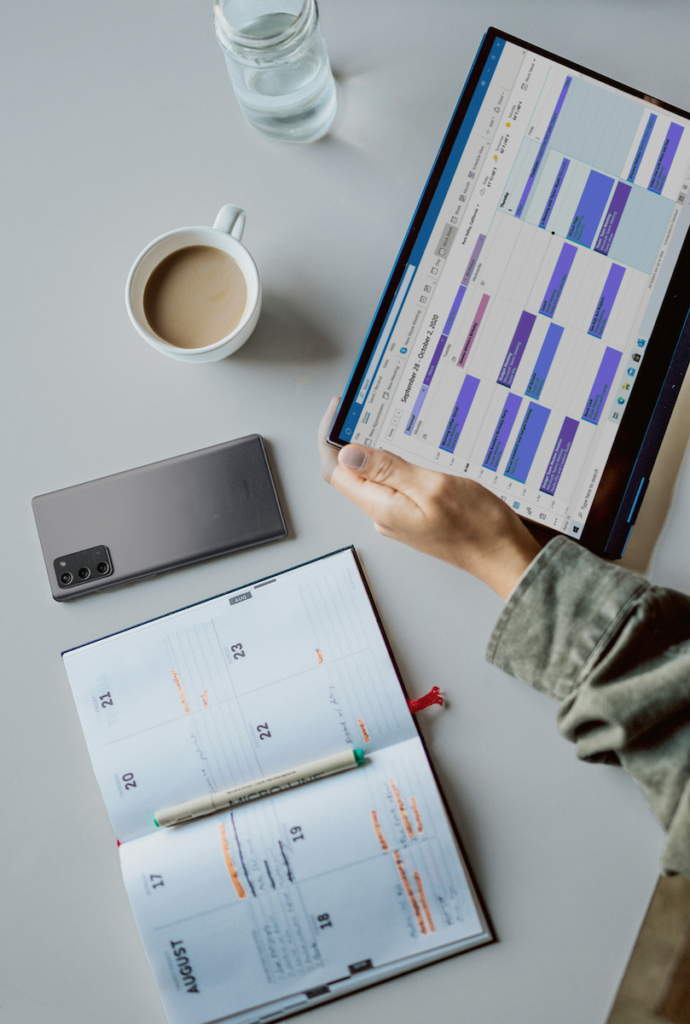 An image of someone using a planner and a digital calendar to manage event logistics.